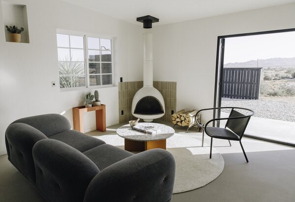 A vintage wood-burning fireplace pops against a green-tiled backsplash in the living room.