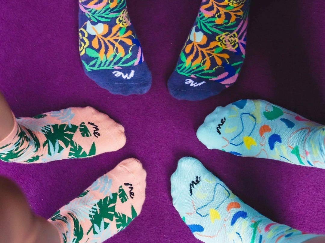 Close-up of three people's feet wearing MeUndies socks in colorful prints