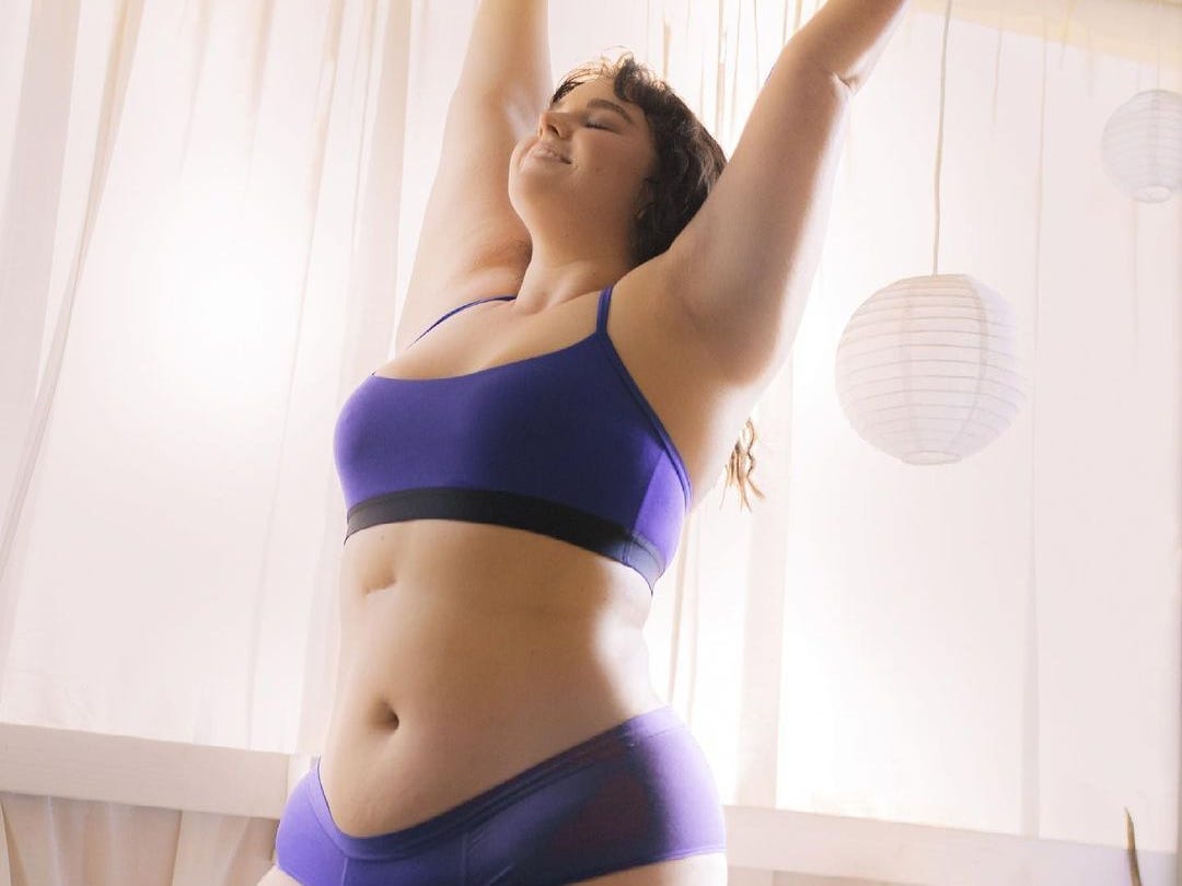 Person wearing a purple MeUndies bralette and underwear and stretching