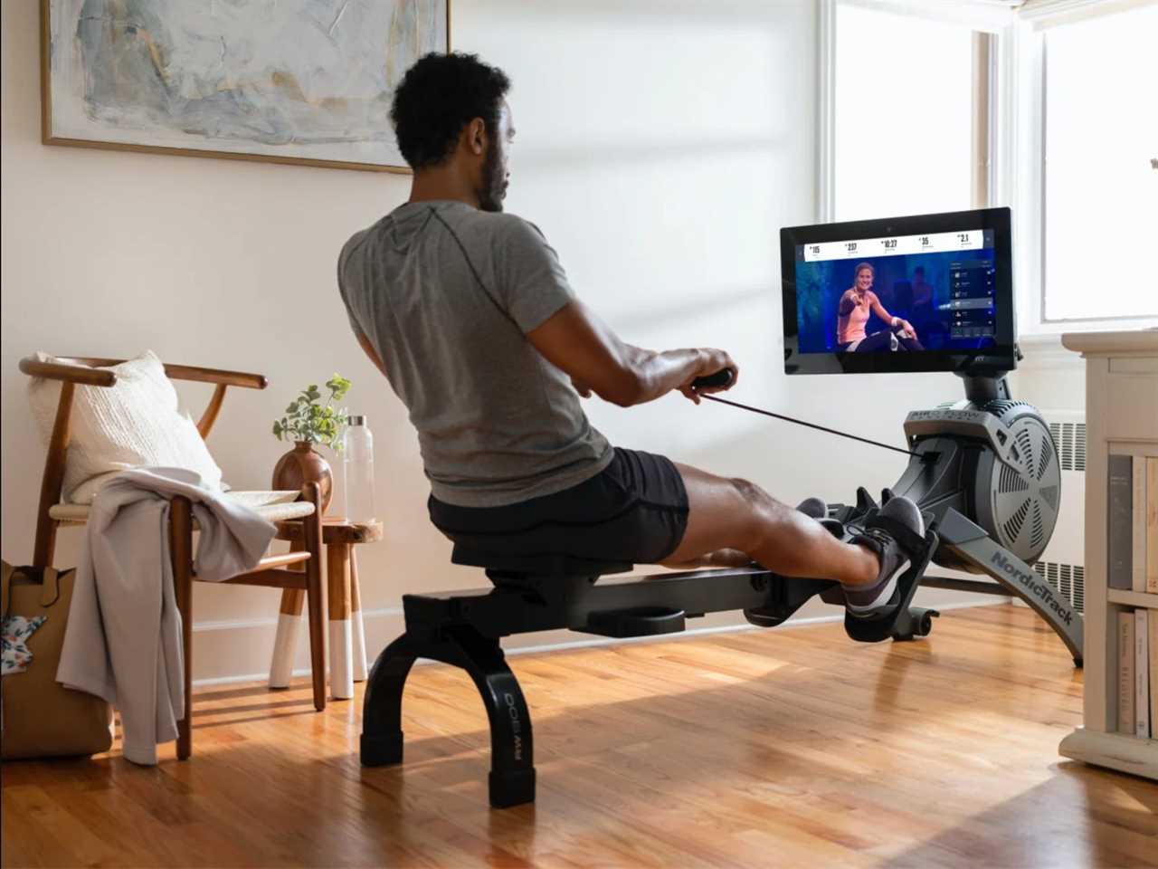 a person uses the NordicTrack's RW900 in a living space.