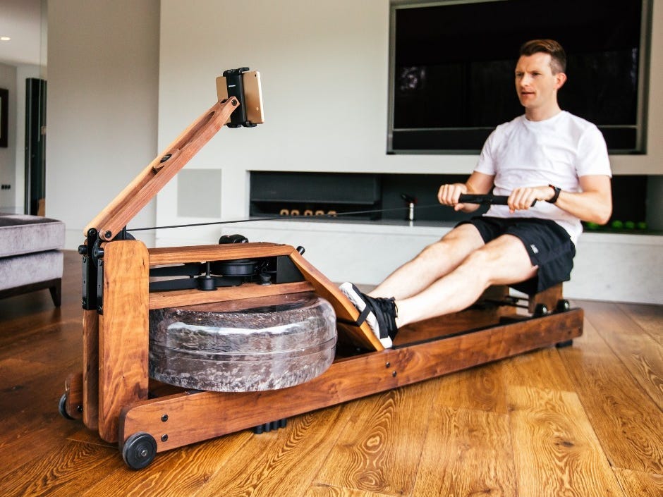 a person uses the WaterRower Natural Rowing Machine in a living space.