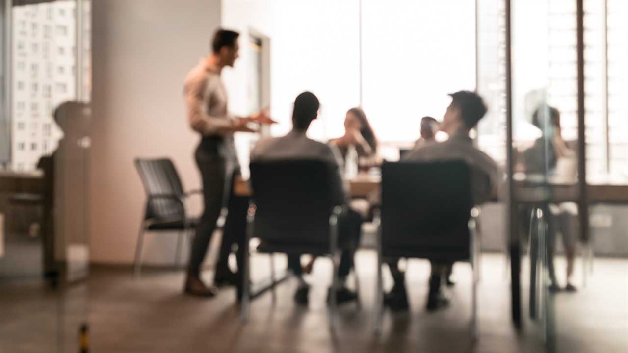 Colleagues having meeting in boardroom, businessman giving speech, blurred photo - stock photo