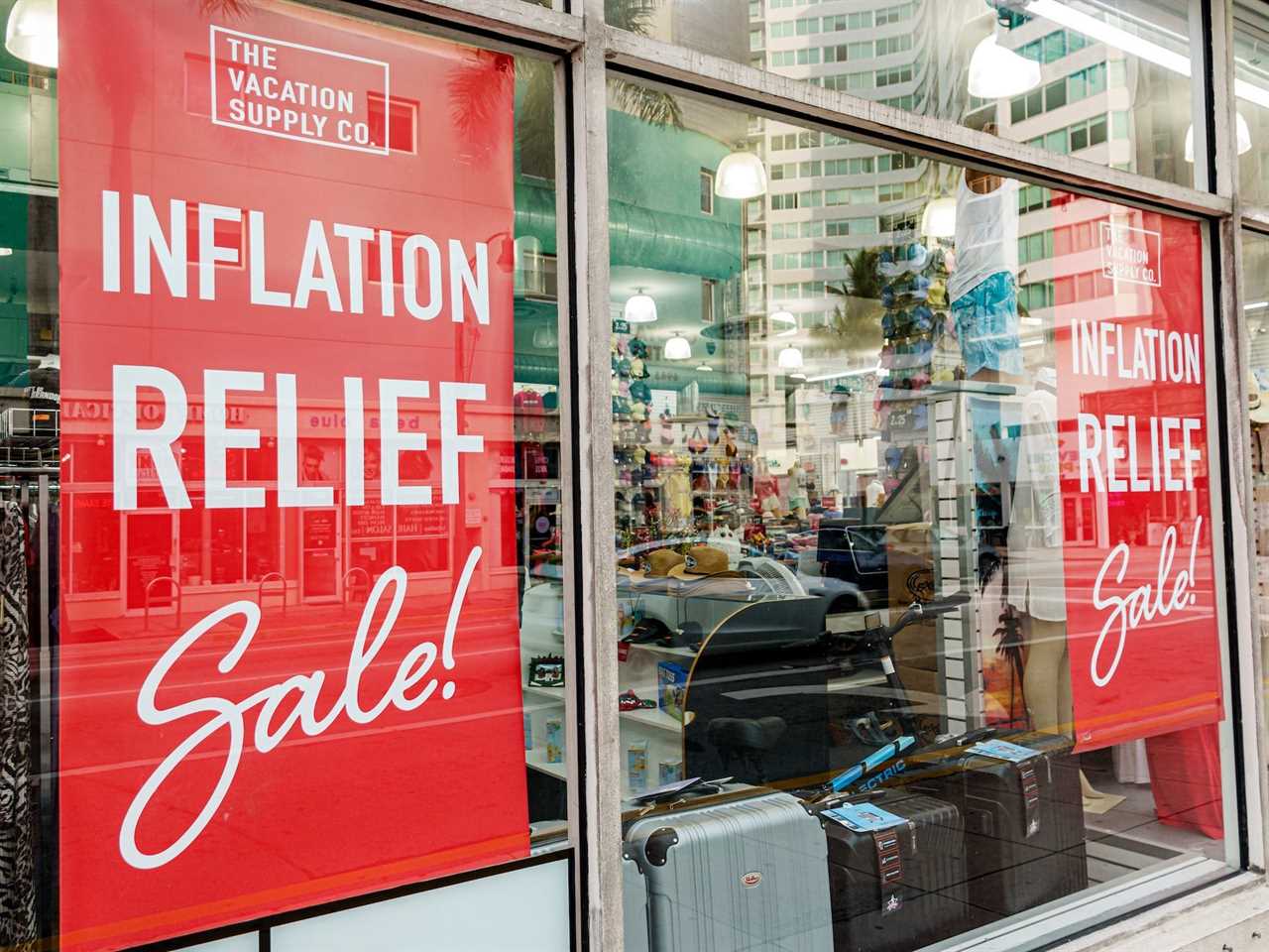 Signs in store windows note an inflation relief sale