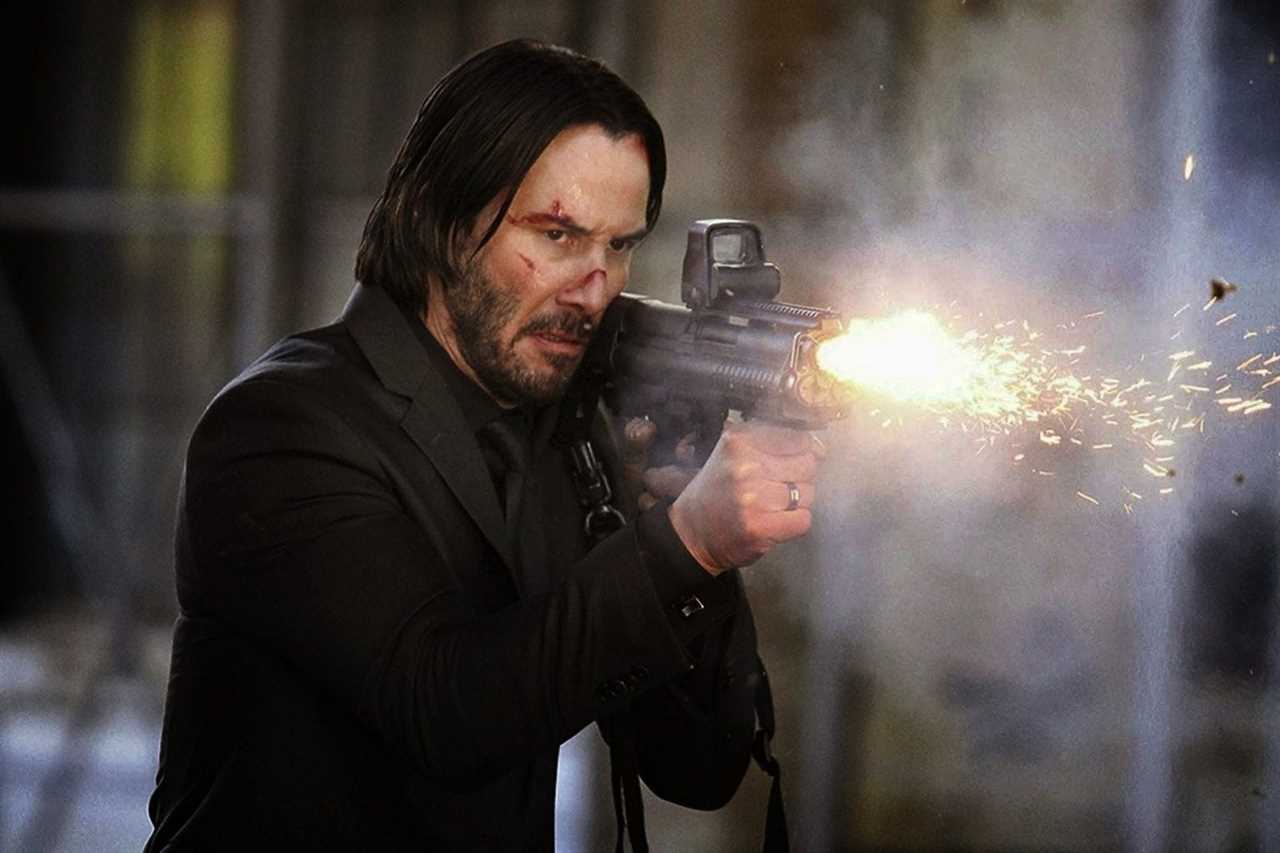 Keanu Reeves as John Wick shooting a shotgun.