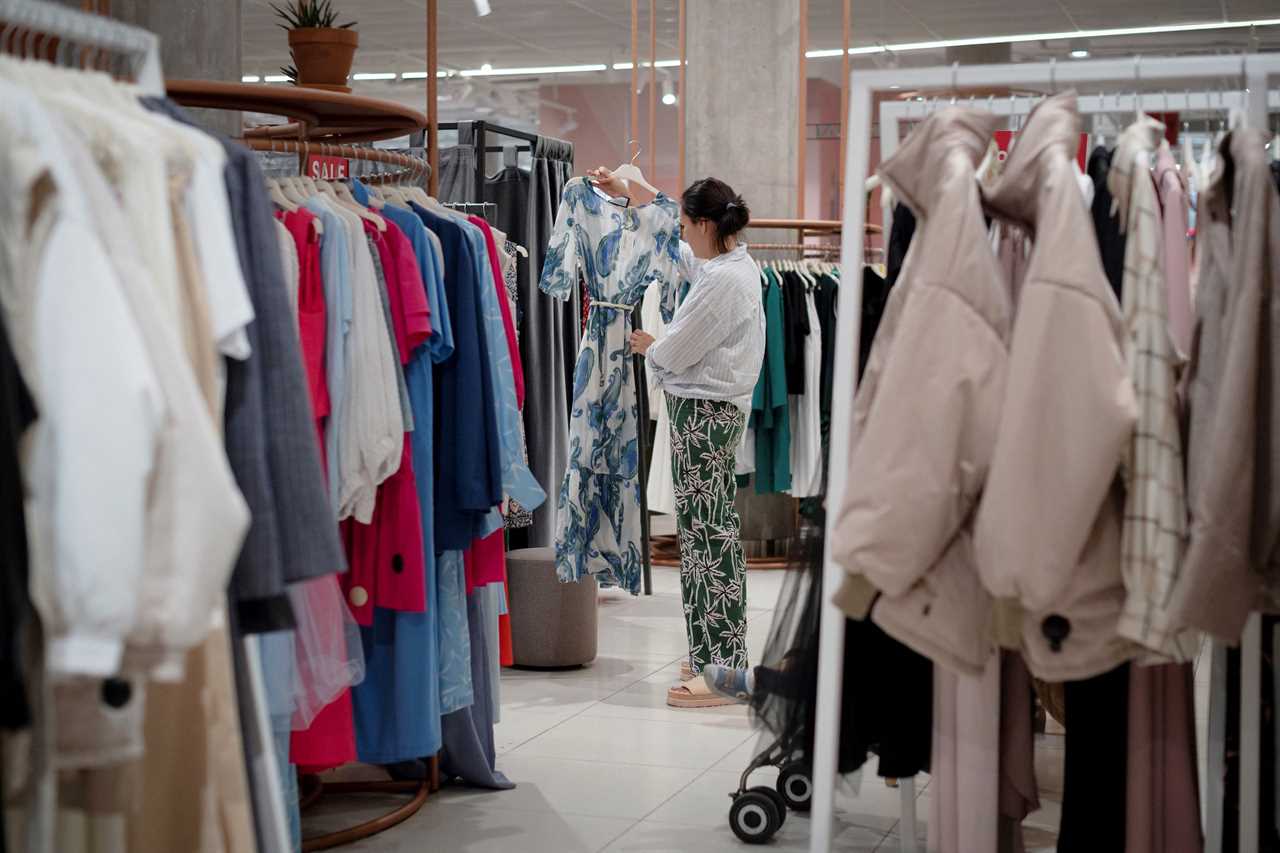 A woman browsing in a brightly lit clothing store