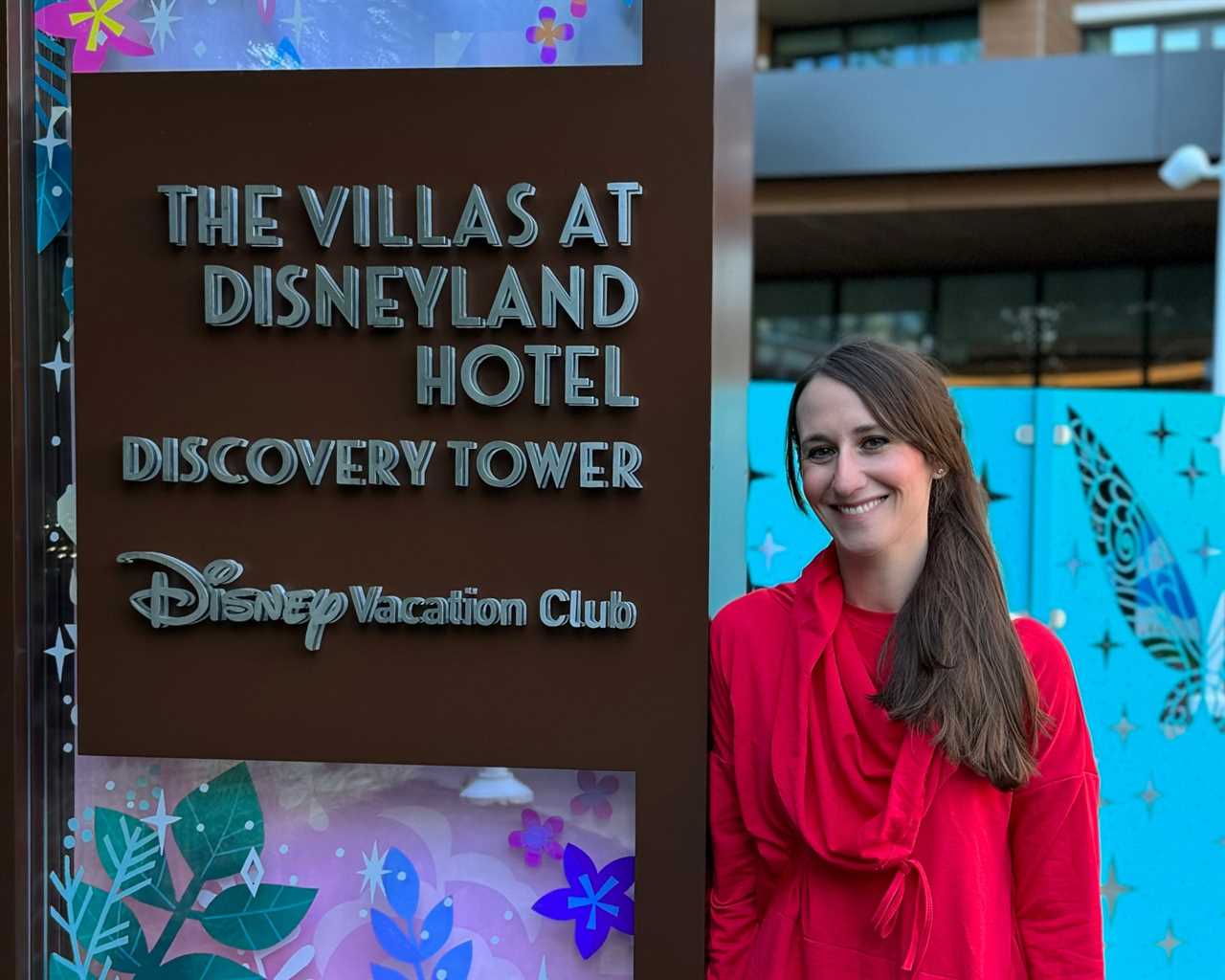 Author Brooke McDonald posing with The Villas at Disneyland Hotel Discovery Tower sign