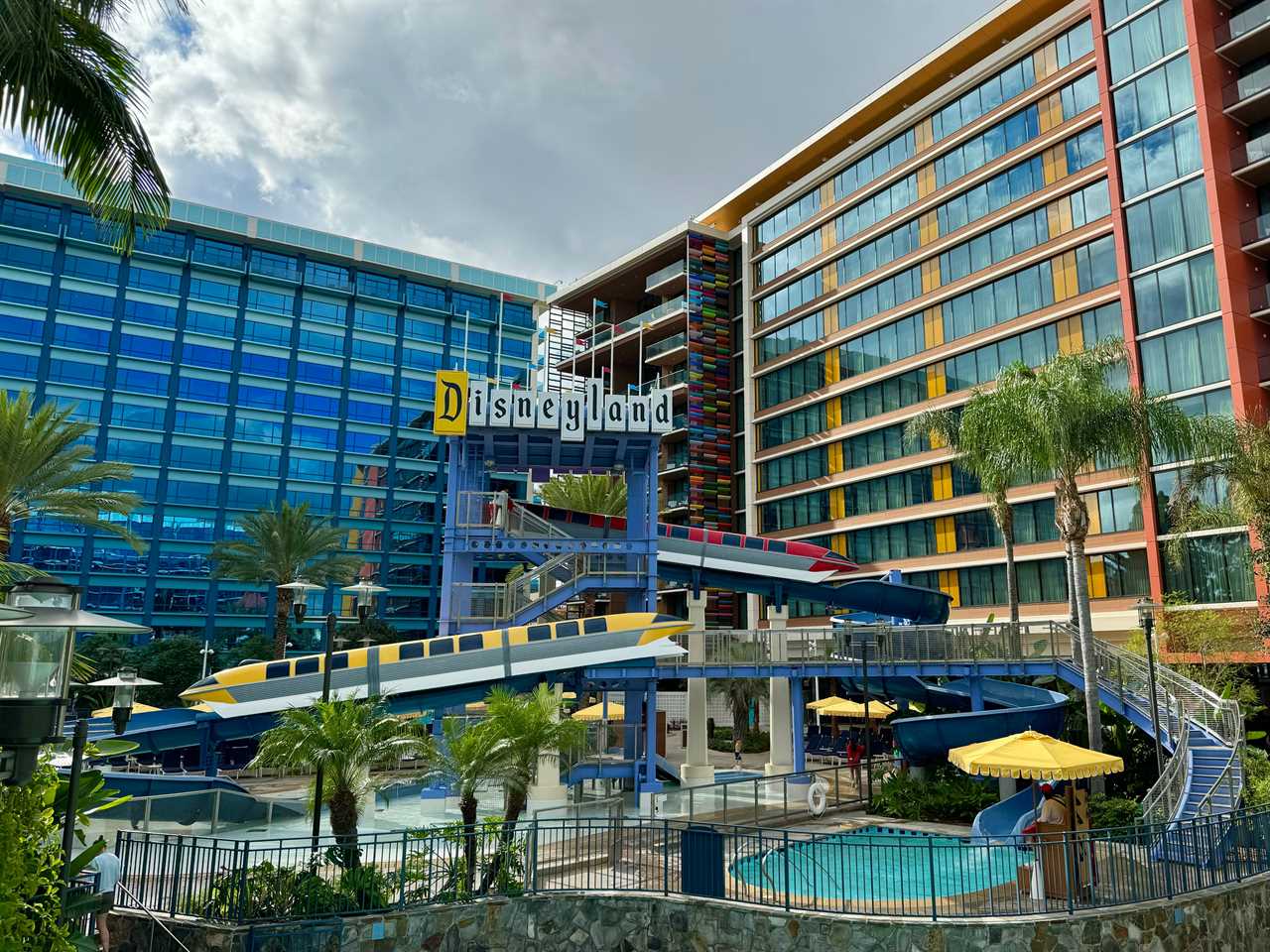 Disneyland Hotel exterior with pool and large walls of buildings including a colorful tower