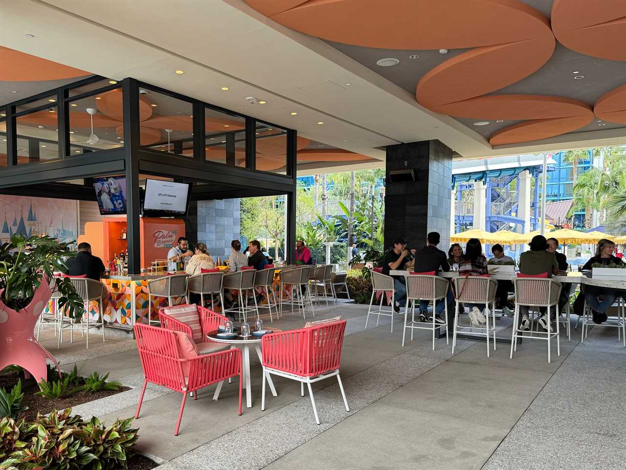 Palm Breeze bar at Disneyland villas with colorful bar and coral chairs and white bar-height chairs