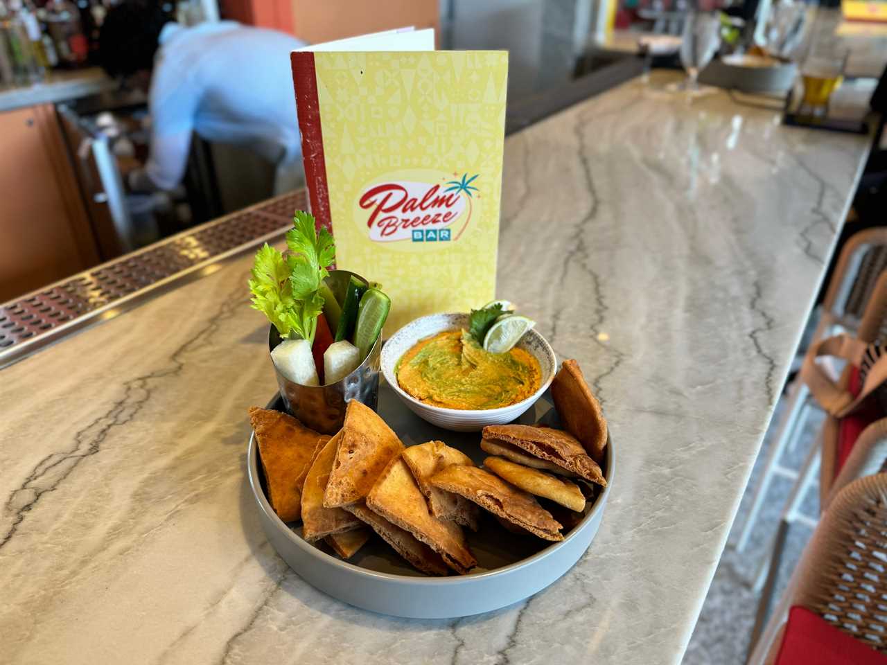 Avocado-lime hummus at Palm Breeze bar in dish with crispy pita chips