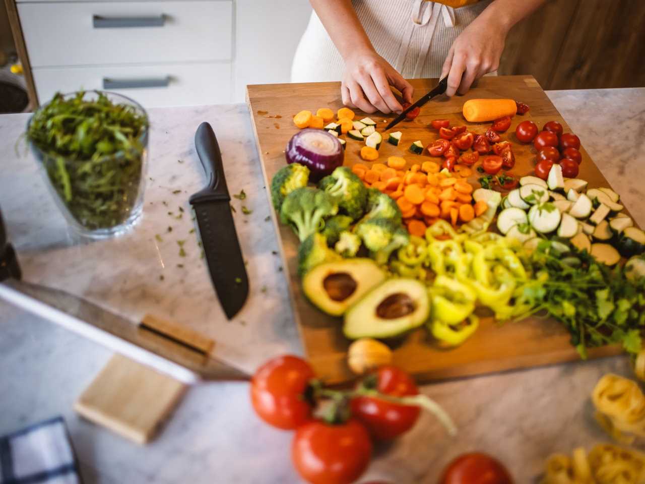 A woman chops vegetables.