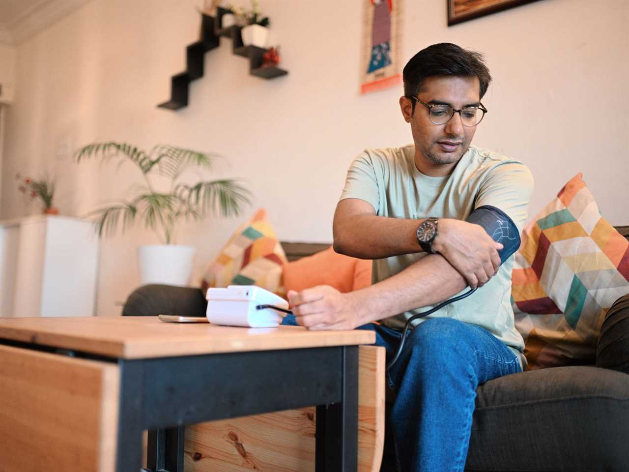 A man checks his blood pressure at home.