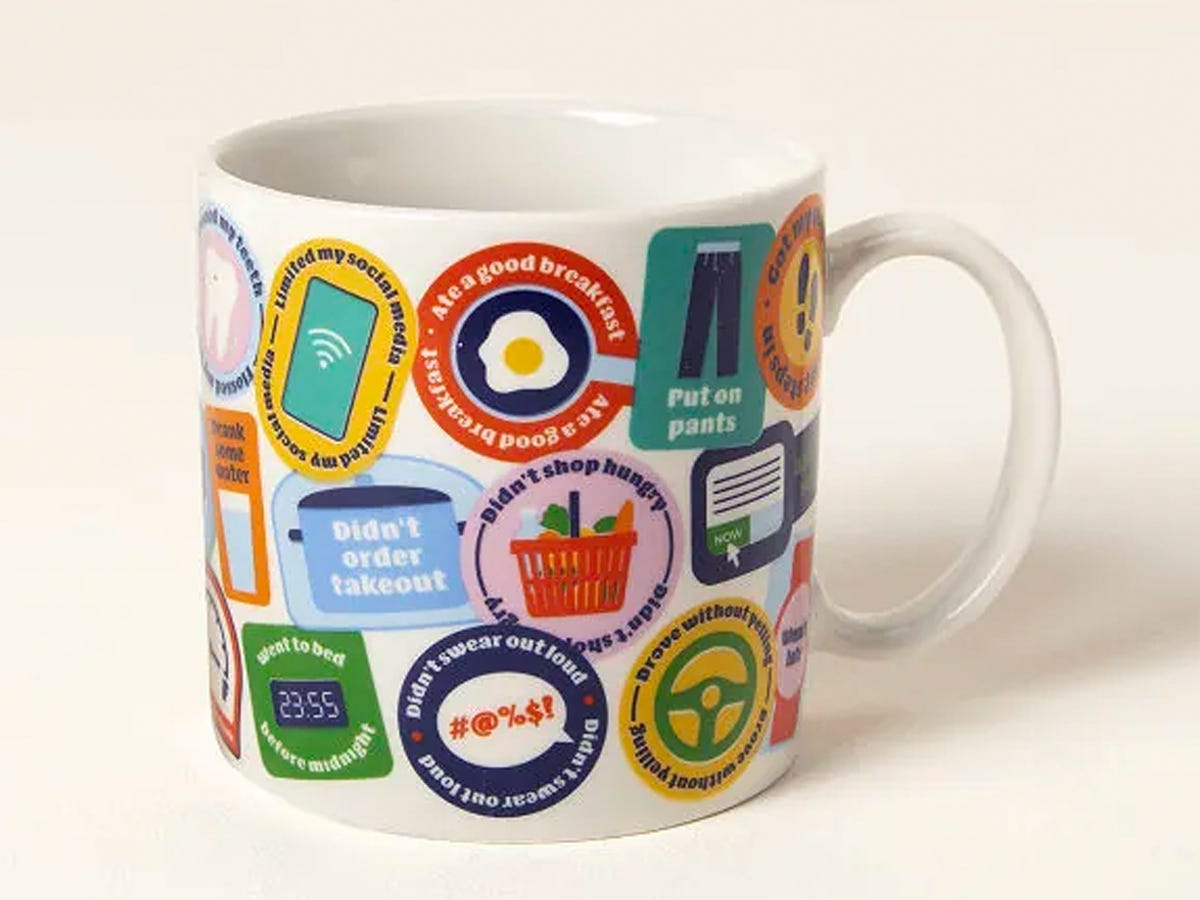 Adulting Merit Badge coffee mug with assorted badge-shaped illustrations of small wins of adulthood printed on it.