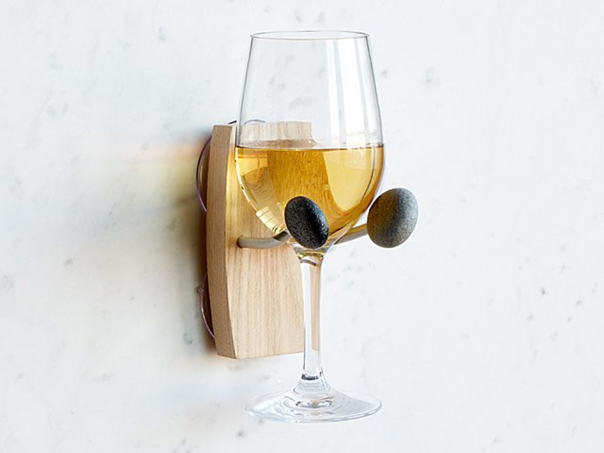 Glass of white wine set in a suction cup wine holder for a bath