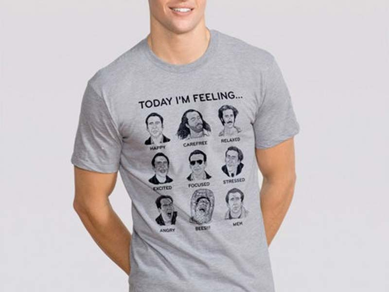 Person wearing a t-shirt with a screen print of assorted illustrations of Nicholas Cage to represent different moods.