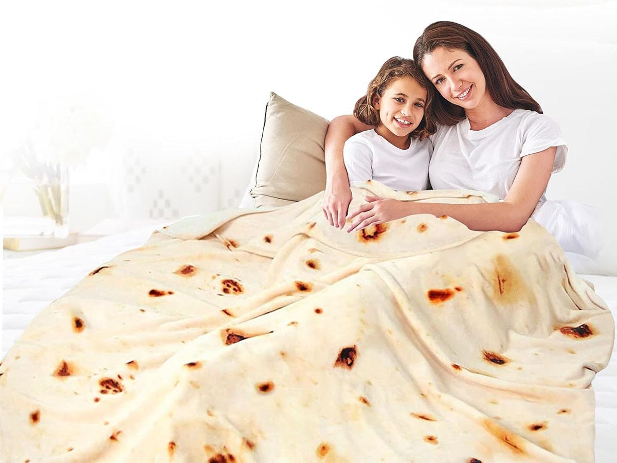 A mother and daughter wrapped up with a tortilla blanket.