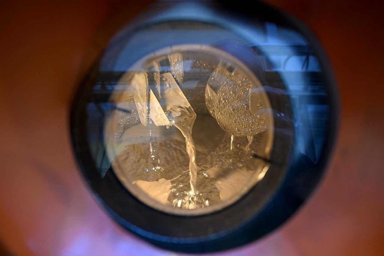 A circular window with molten salt pouring onto a surface