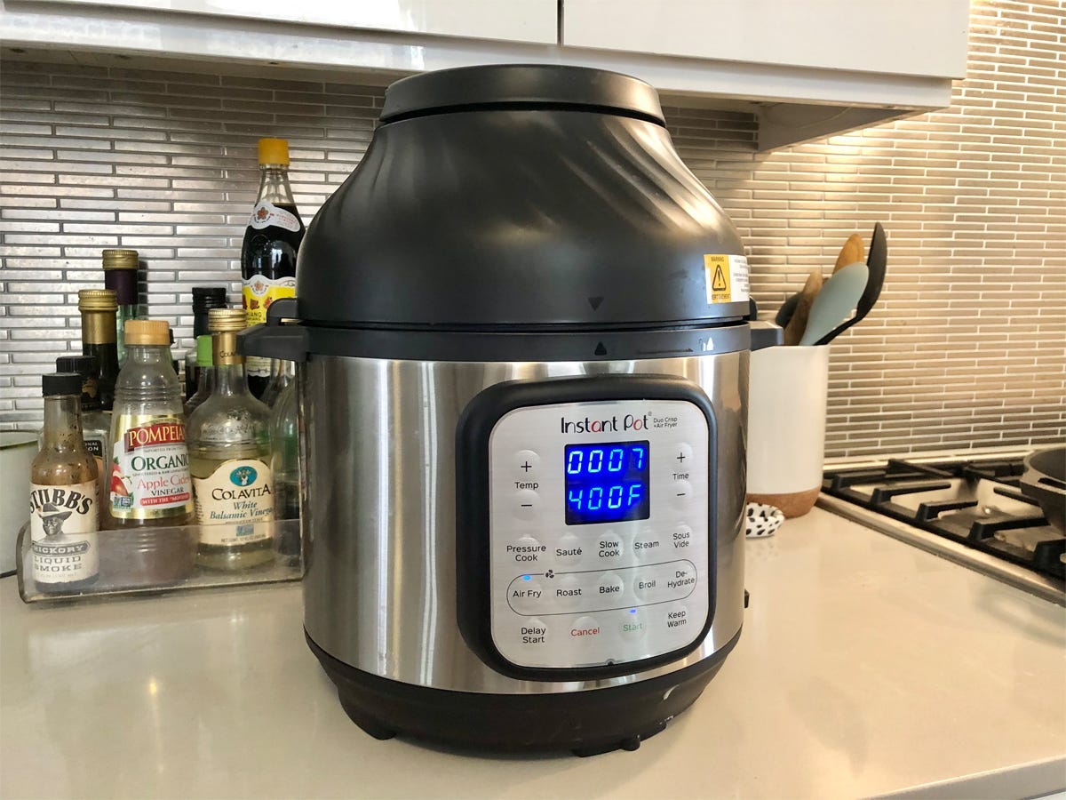 The Instant Pot Duo Crisp sits on a counter by bottles of cooking ingredients.