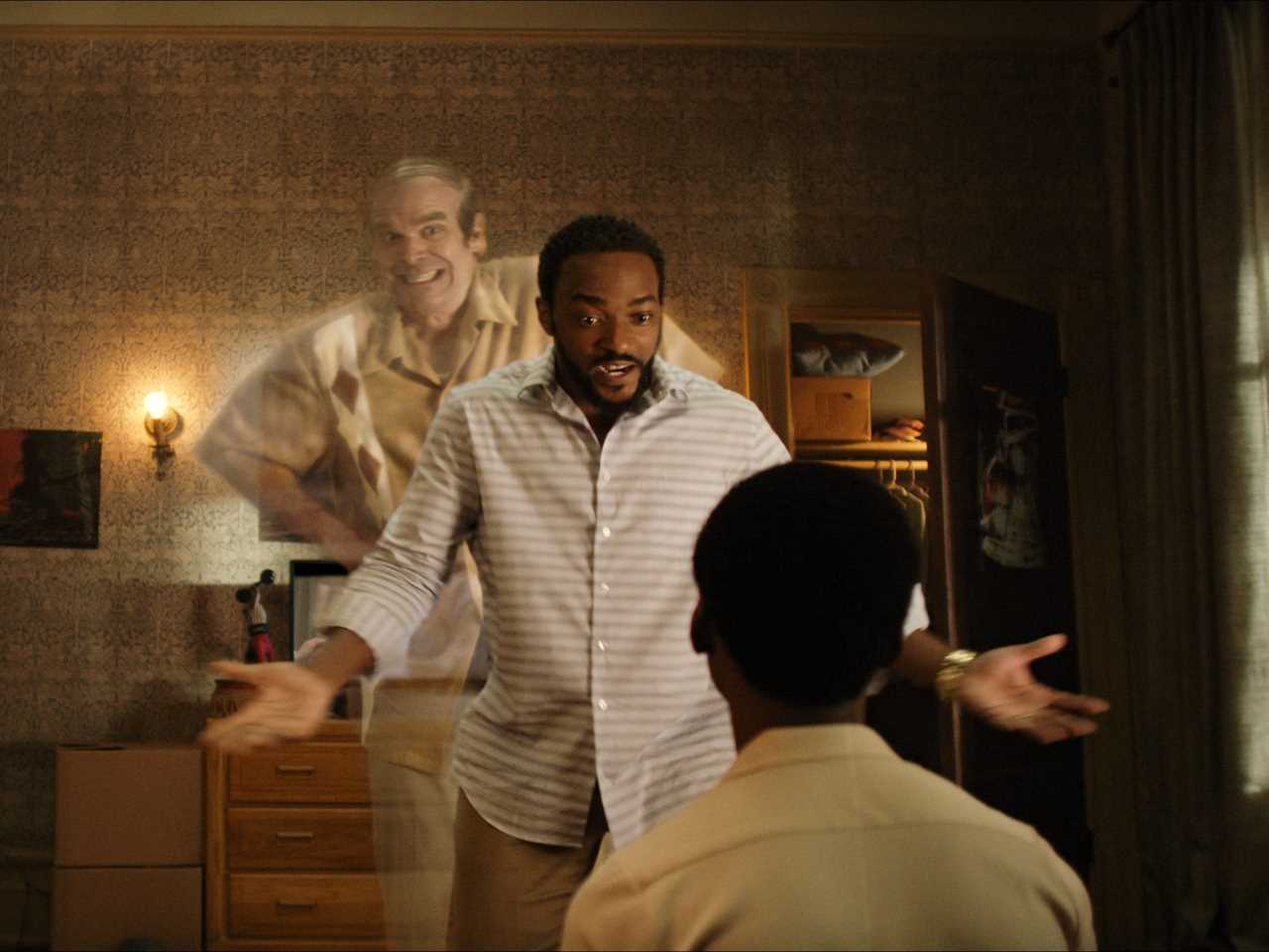 david harbour poping up as a ghost behind anthony mackie in a scene from we have a ghost