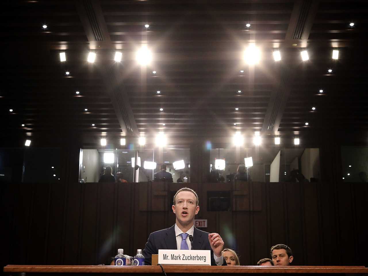 Mark Zuckerberg testifying in the Hart Senate Office Building in April 2010 over the Cambridge Analytica scandal. He is sitting in front of a plaque that has his name on it.