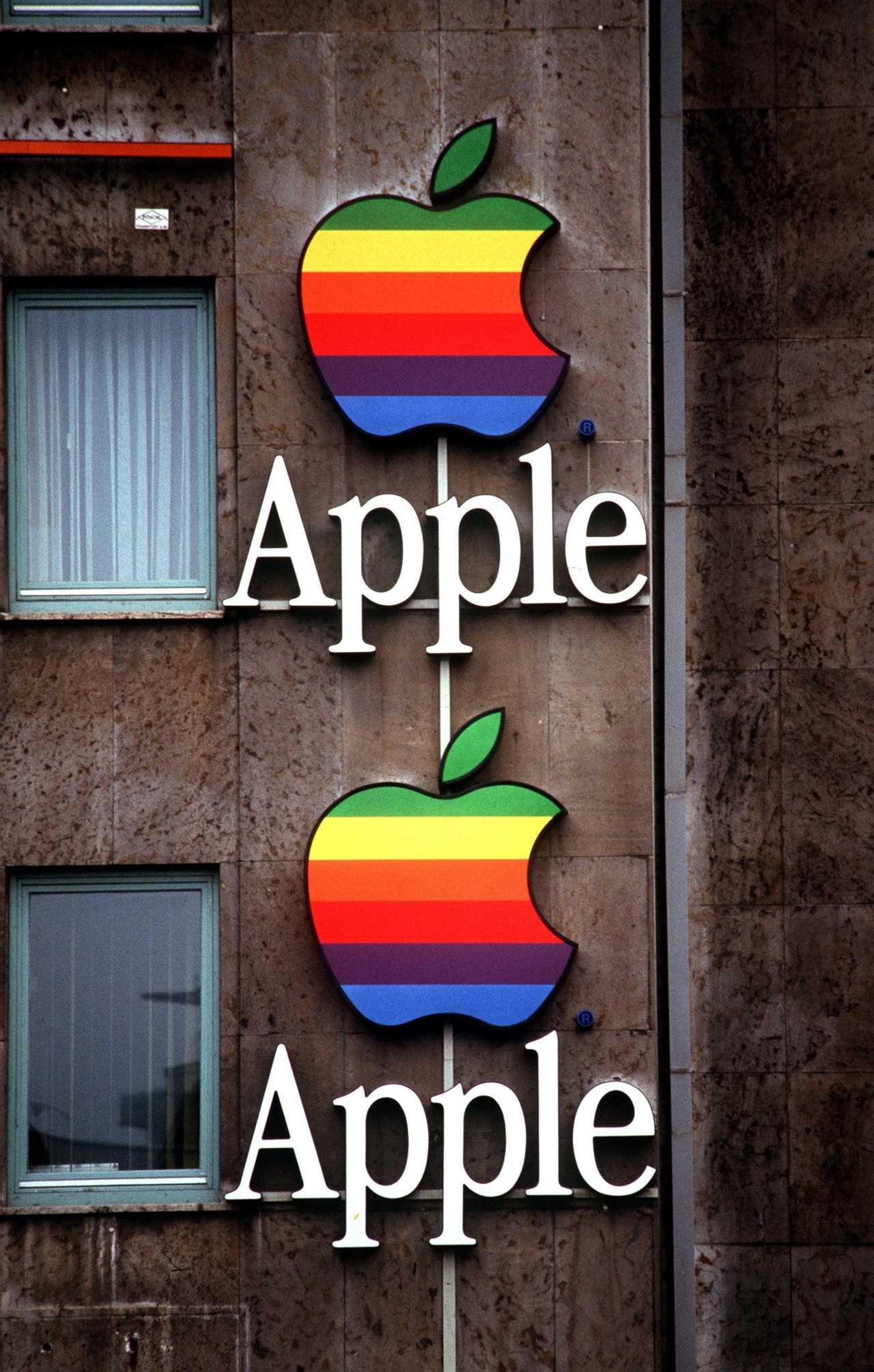 Two retro Apple logos, icons in the shape of bitten apples with rainbow stripes, on the side of a building