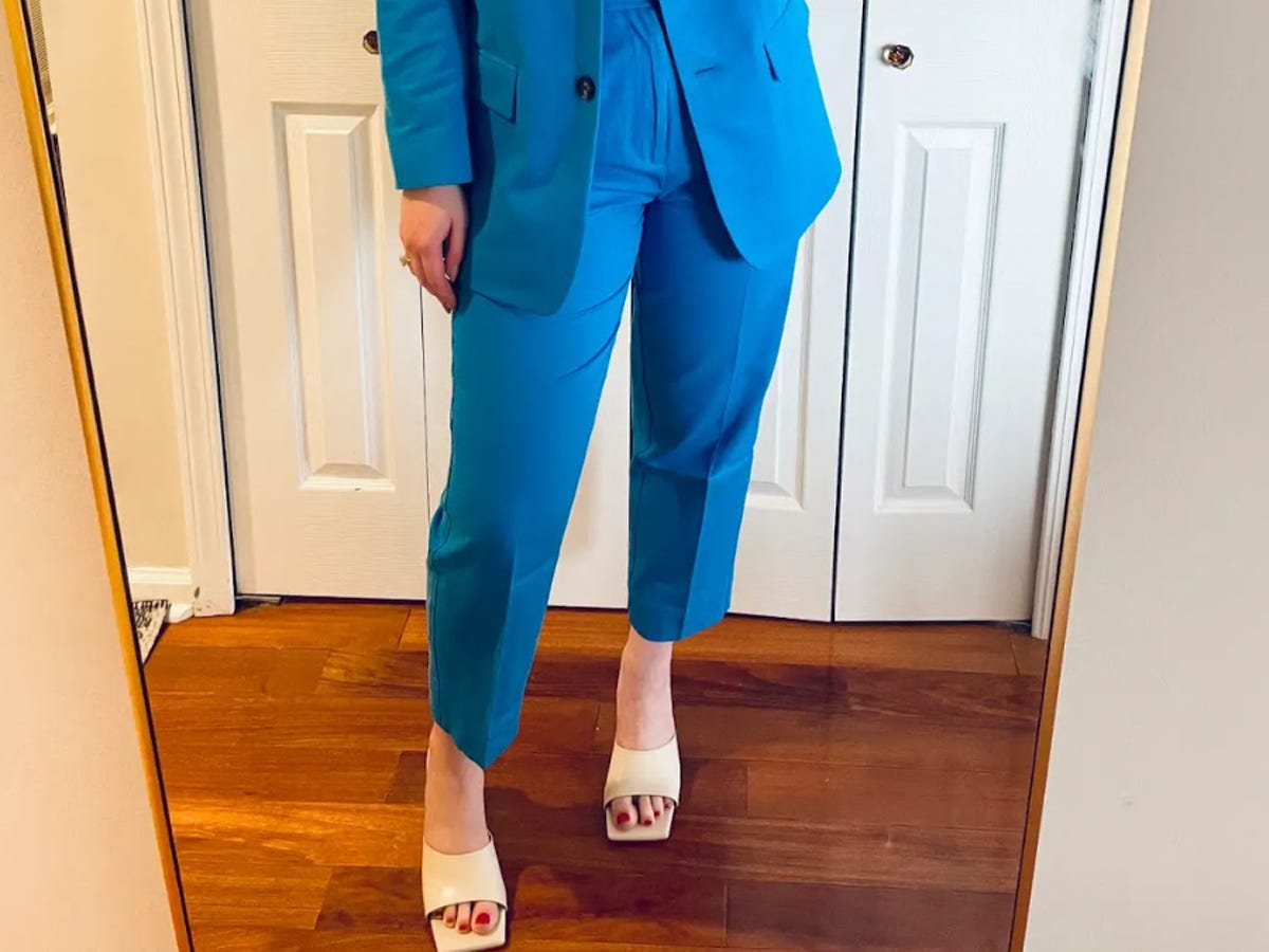 Person wearing the Everlane The Tencel Way-High Taper Pant in brilliant blue and taking a photo in front of a mirror.