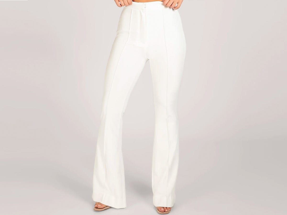 A person wearing the Meshki Zendaya Highwaisted Flare Pants in white.