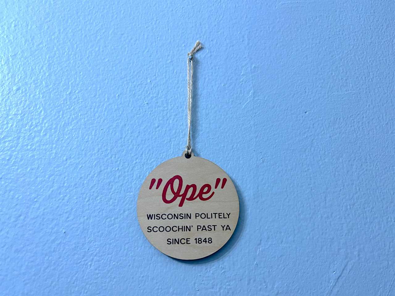 A sign that reads: "Ope" Wisconsin politely scoochin' past ya since 1848.