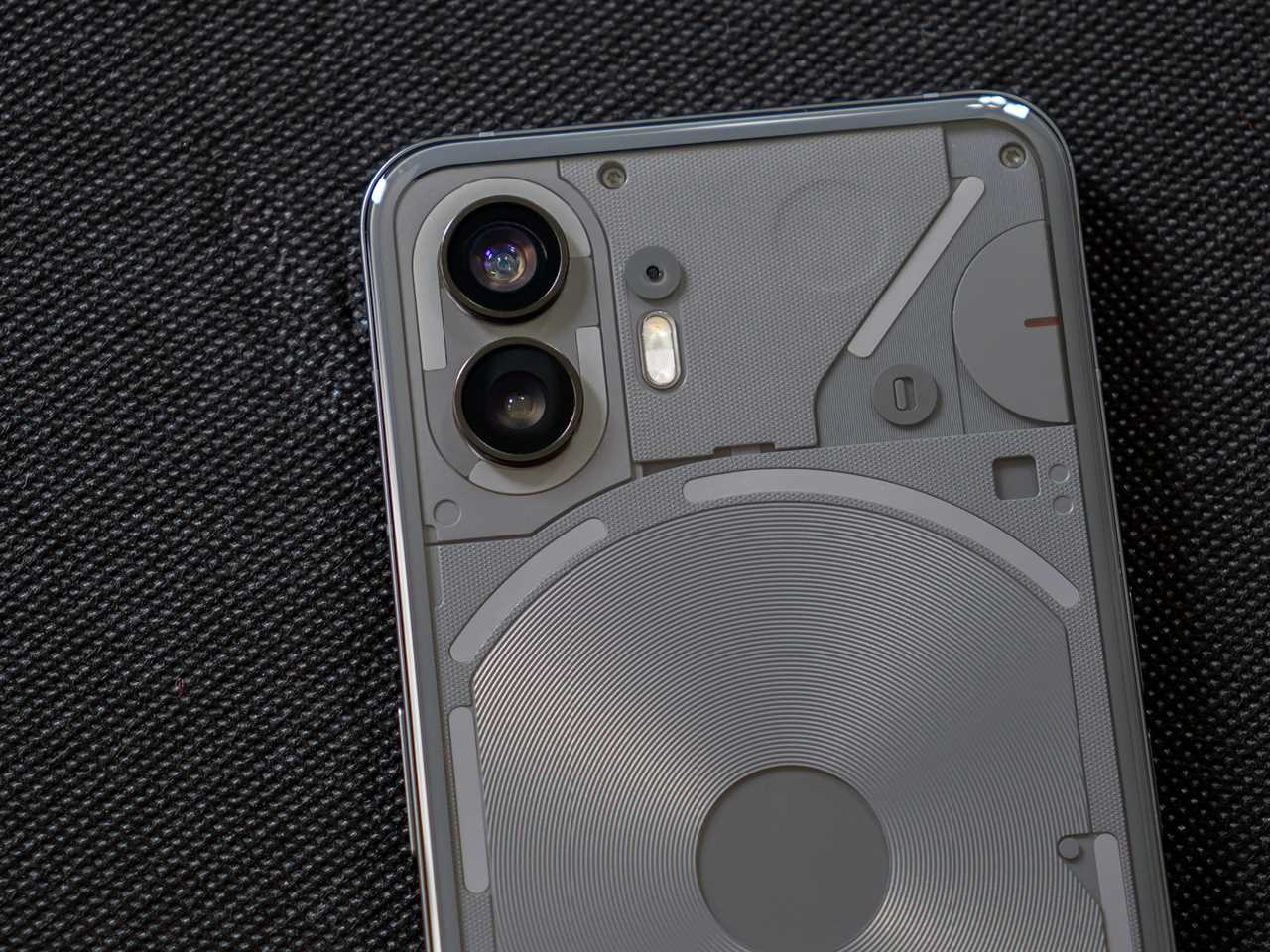 The Nothing Phone 2’s rear cameras, with the phone laying on a black fabric background.