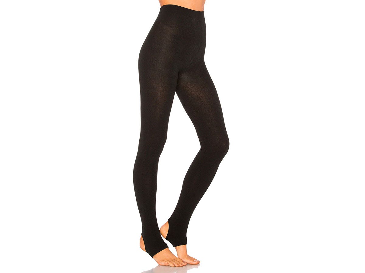 Woman wearing black plush stirrup leggings.