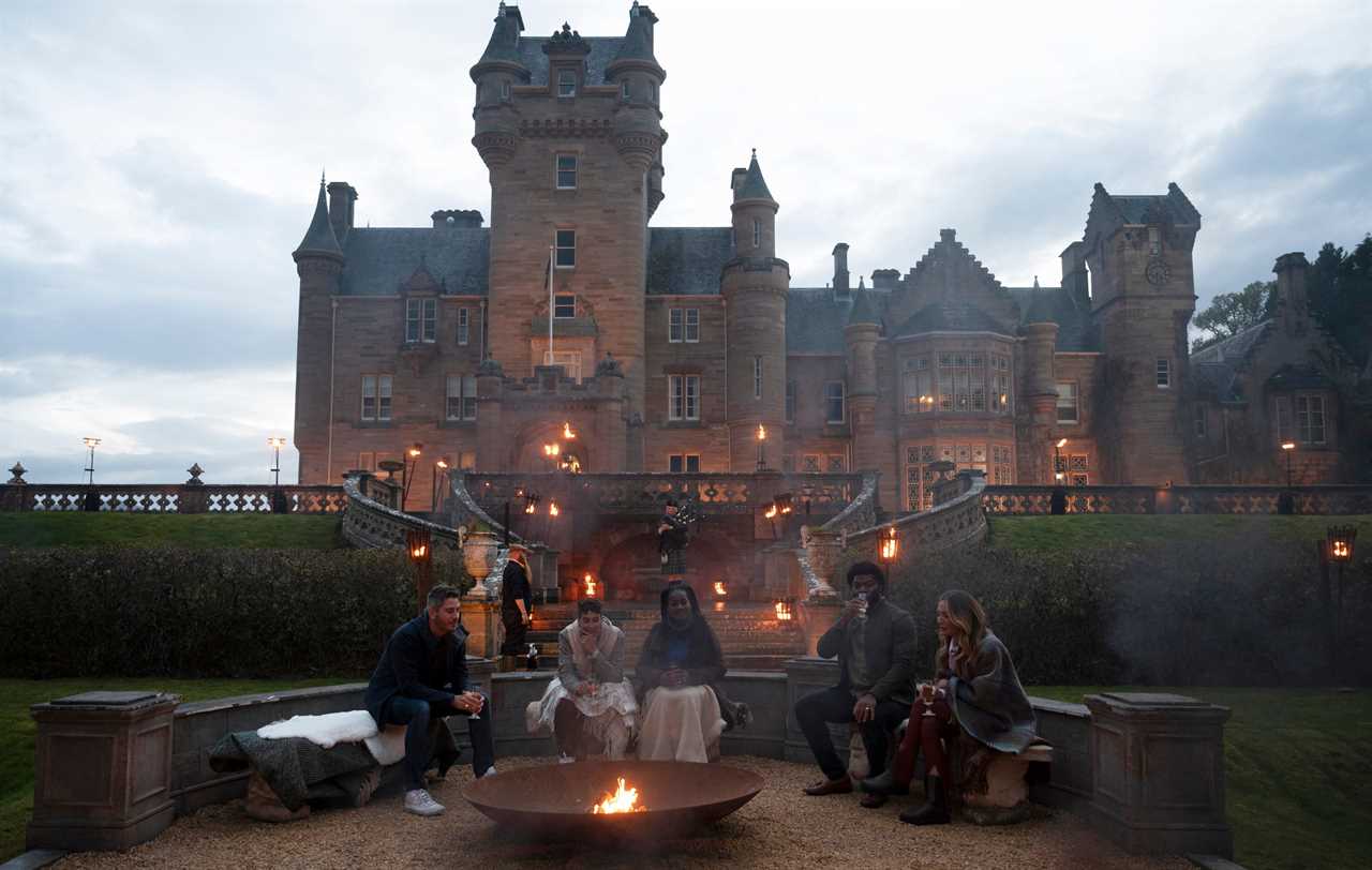 The Traitors season one cast members sitting in front of castle