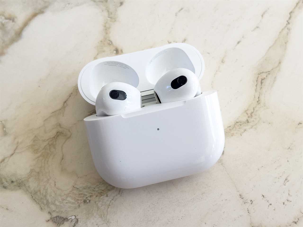 The 3rd-generation AirPods in their case on a marble countertop.