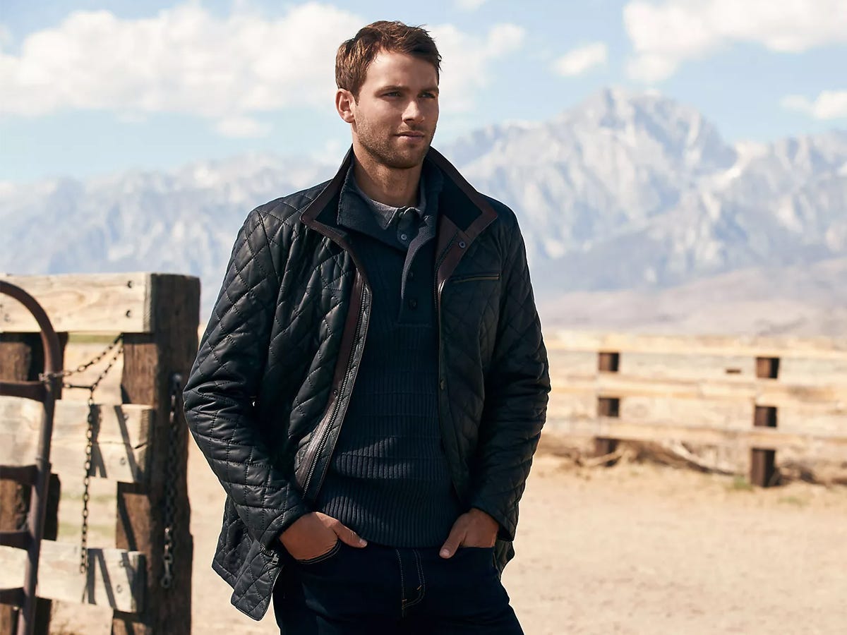 A model wearing a Overland Christian Quilted Italian Lambskin Leather Coat in a mountainous area.