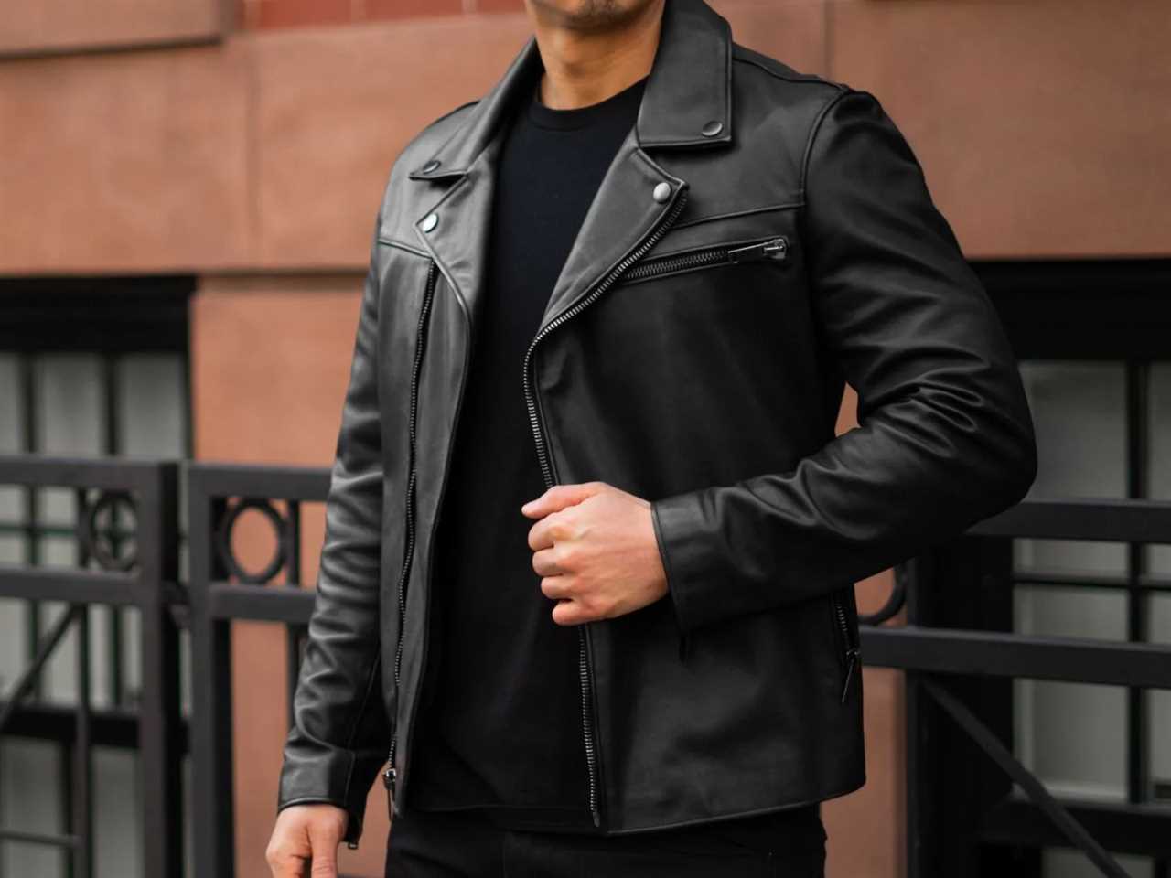 A model wearing the Thursday Boot Co. Motorcycle Jacket in black leather outside.