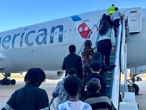 High school students board an American jet as part of a field trip.