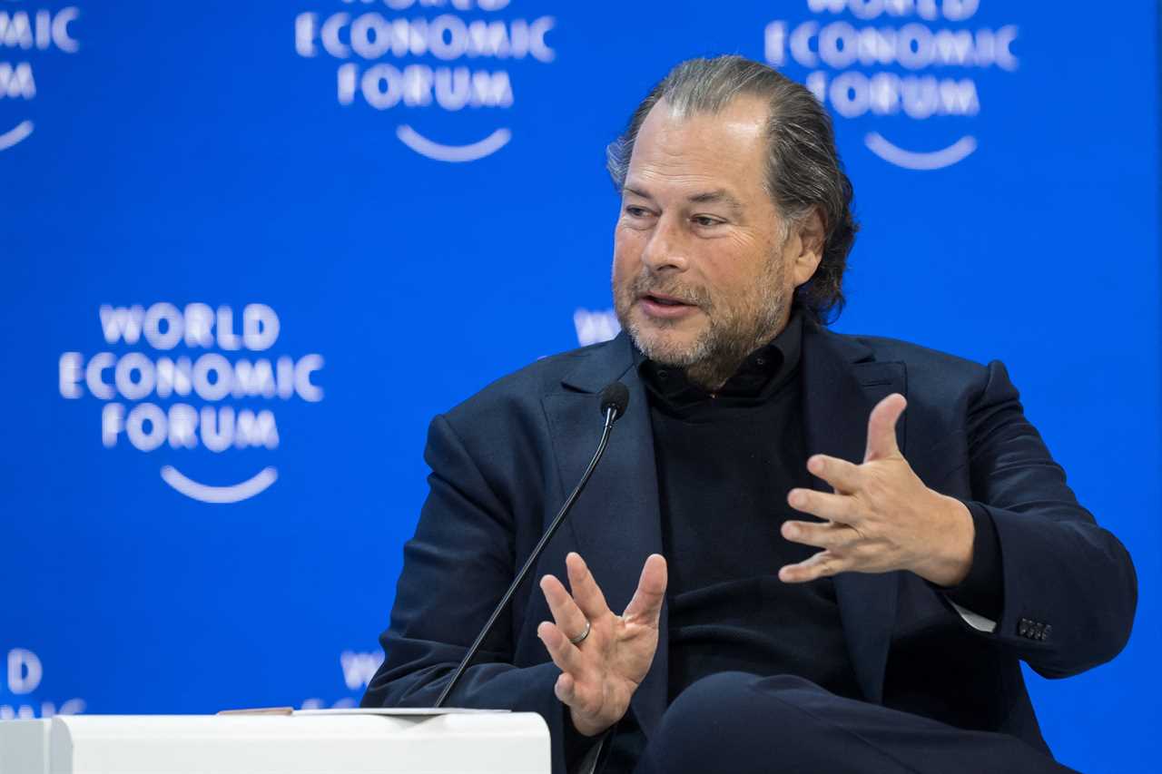 Marc Benioff speaking on a panel at the World Economic Forum wearing a black suit and black shirt