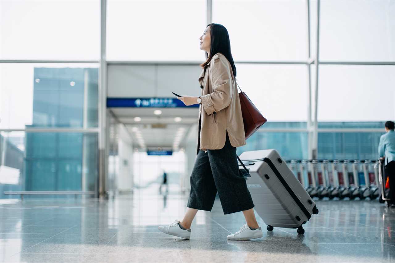 Woman pulling luggage through airport.