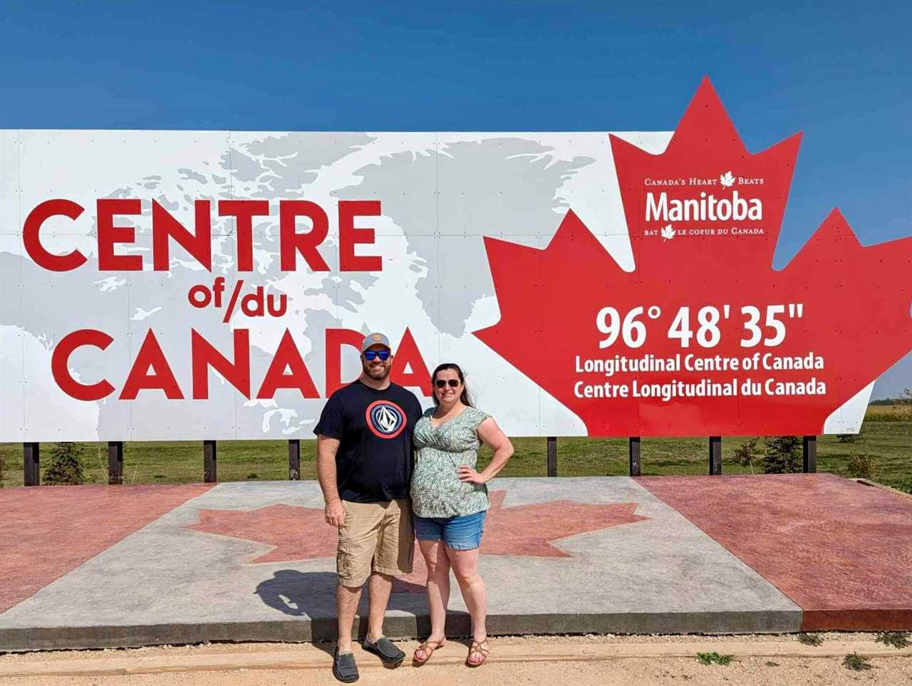 A man and a woman standing in front of a sign that reads "Centre of/du Canada."