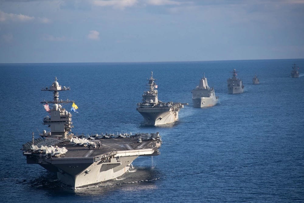 A line of military ships sailing in the sea