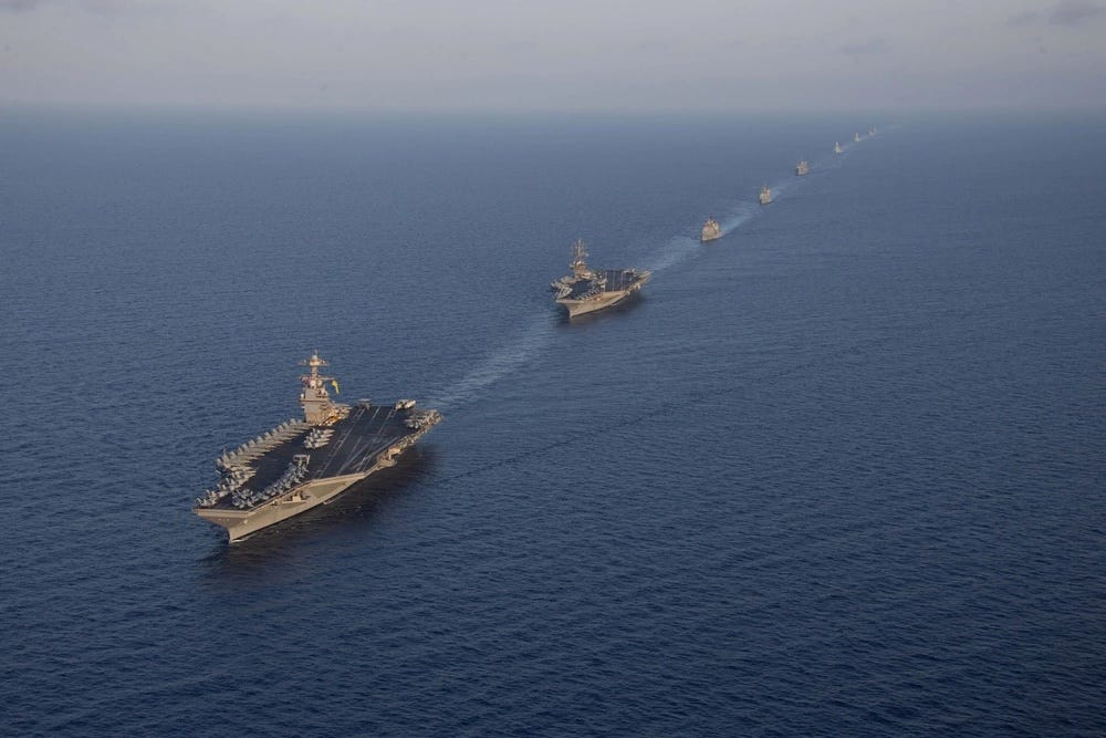 a line of military ships sail in formation