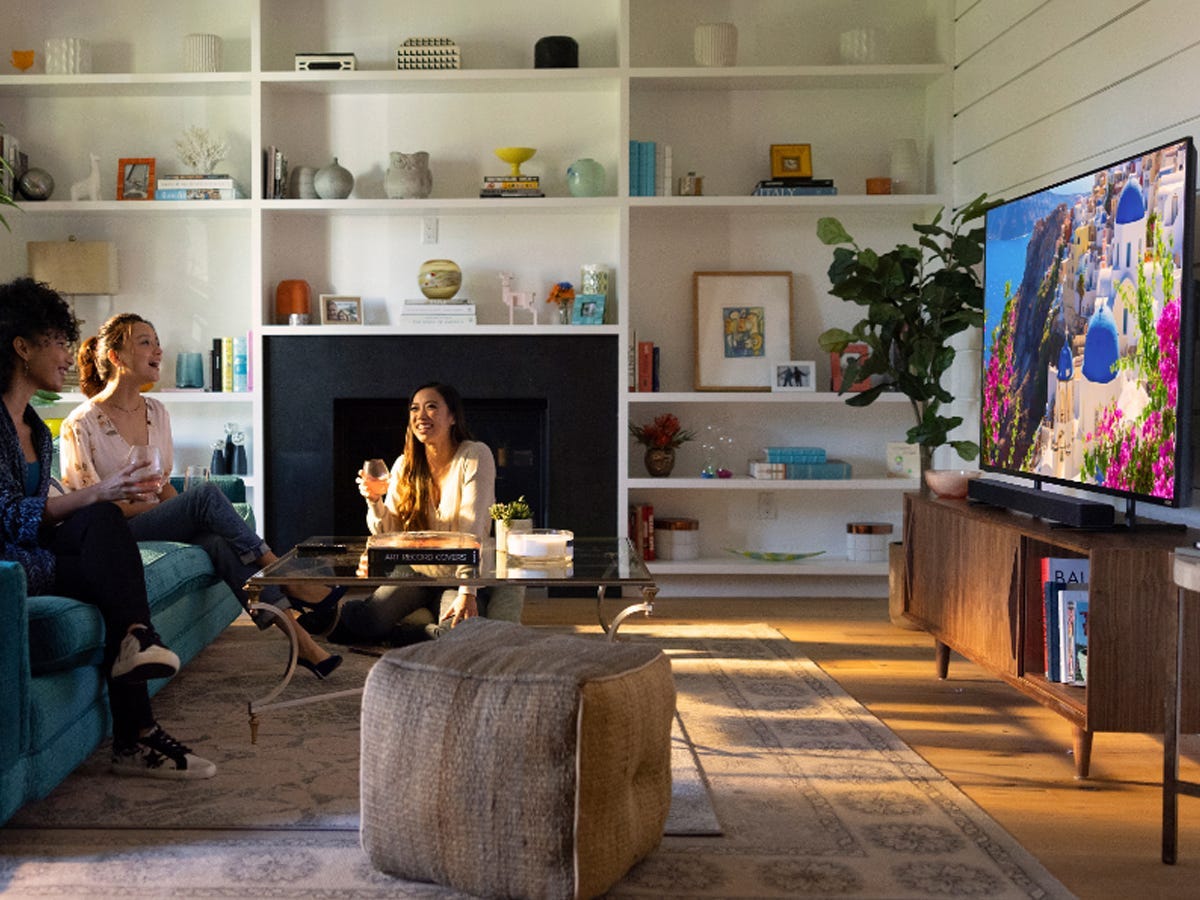 A group of people watching TV in a furnished living room using the V-Series V21d-J8.