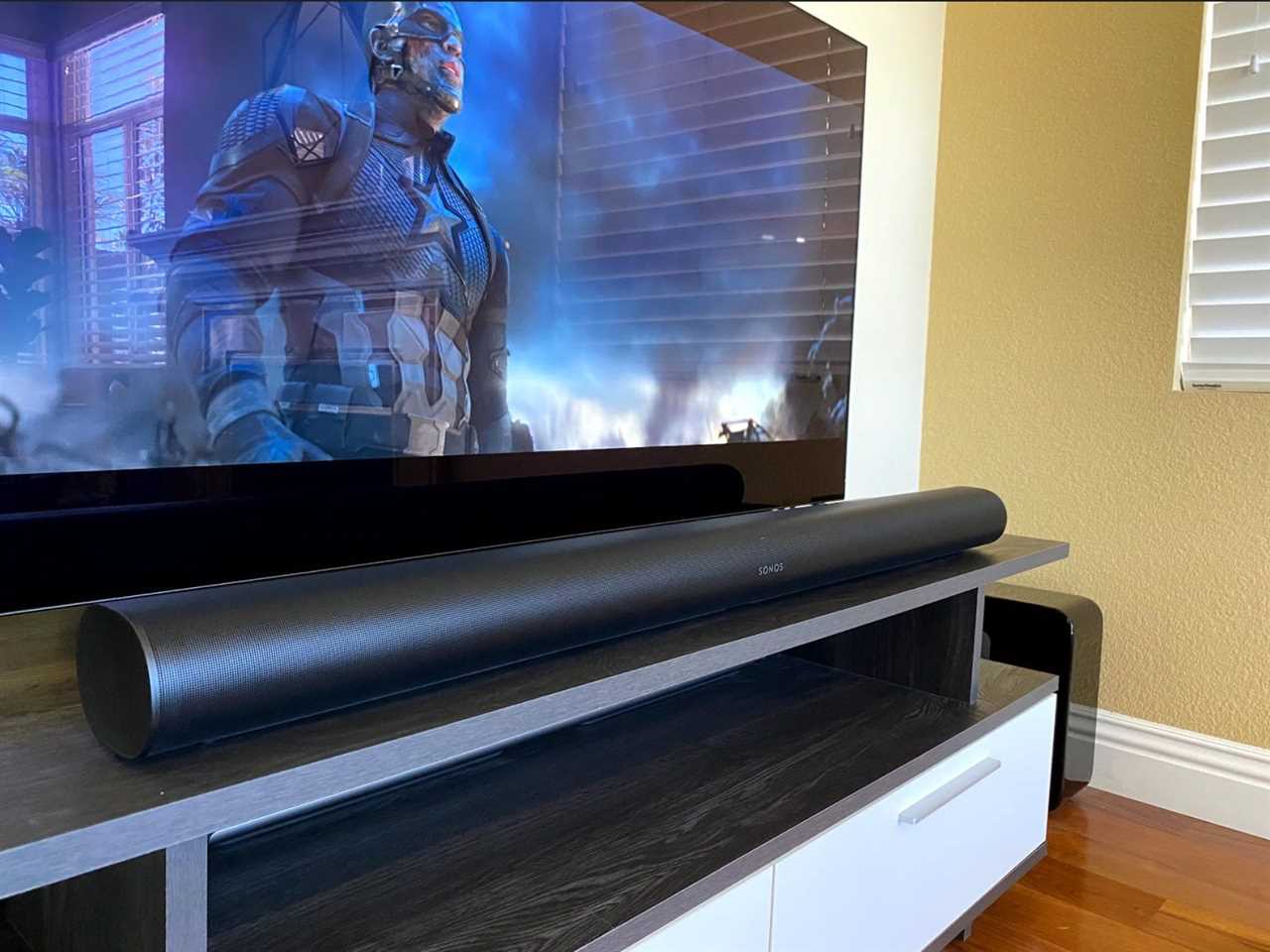 A Sonos Arc speaker on a TV stand.