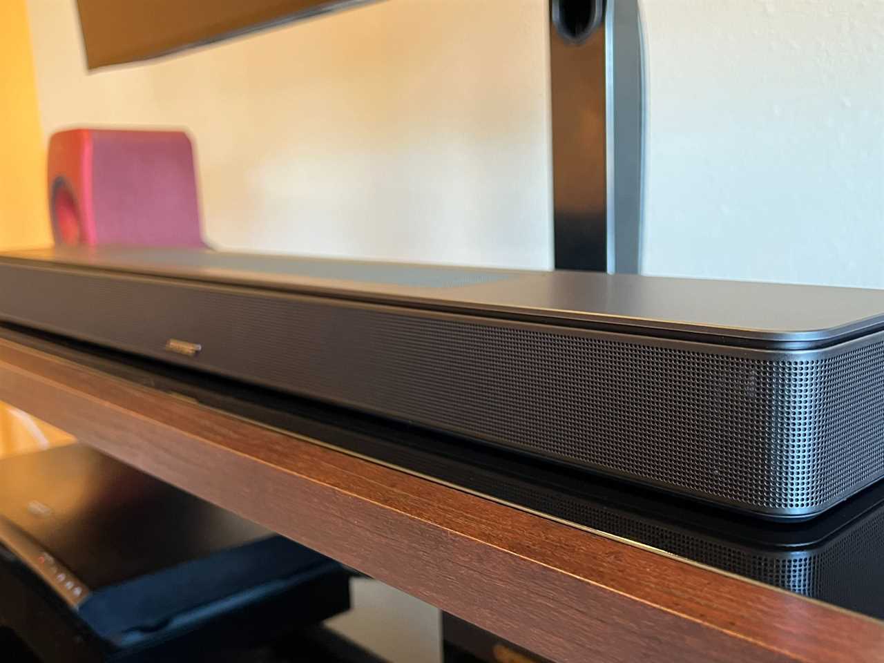 The Bose Smart Soundbar 600 is shown on a black and brown console.