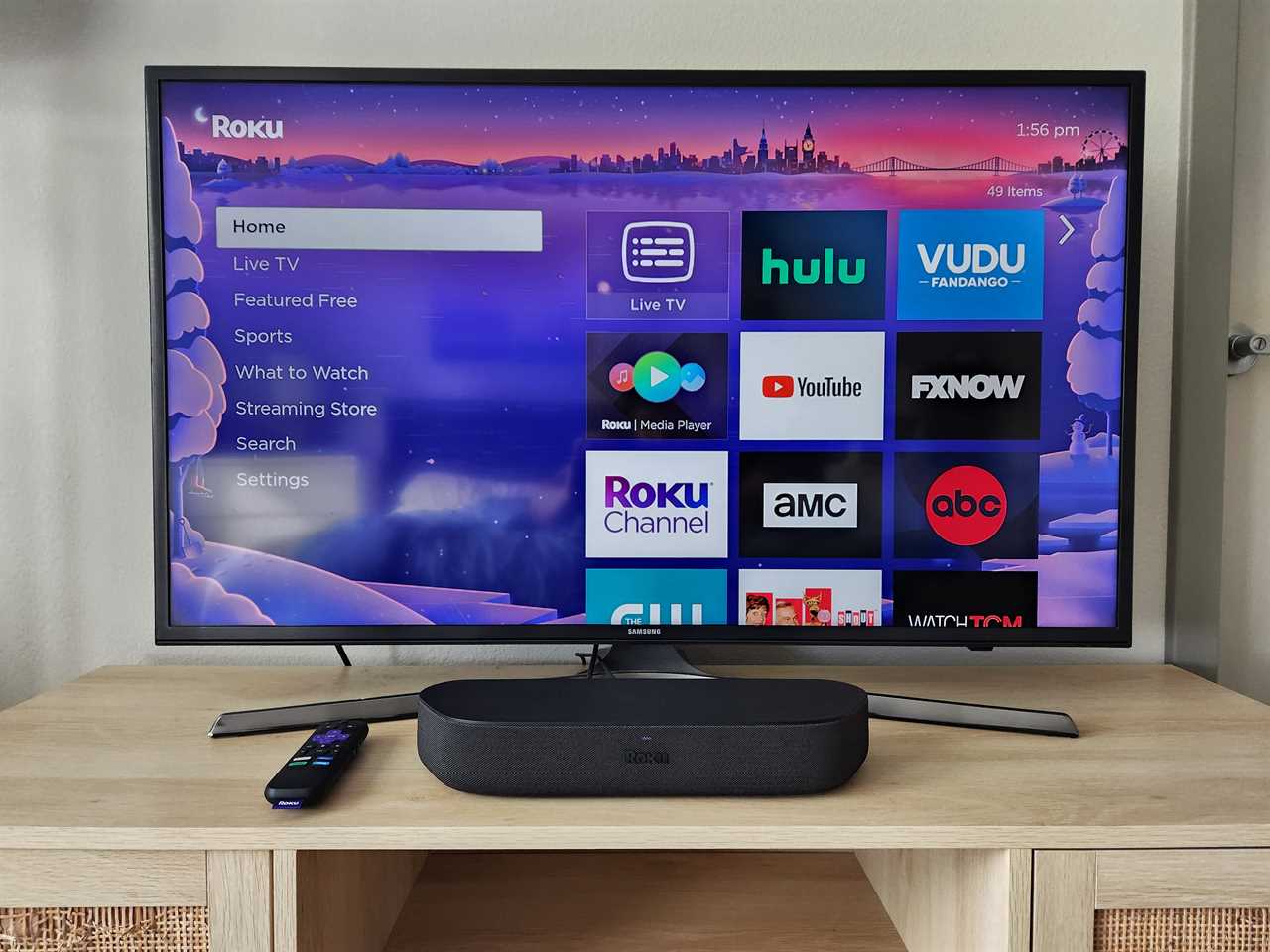 A Roku Streambar on an entertainment console with a Samsung TV