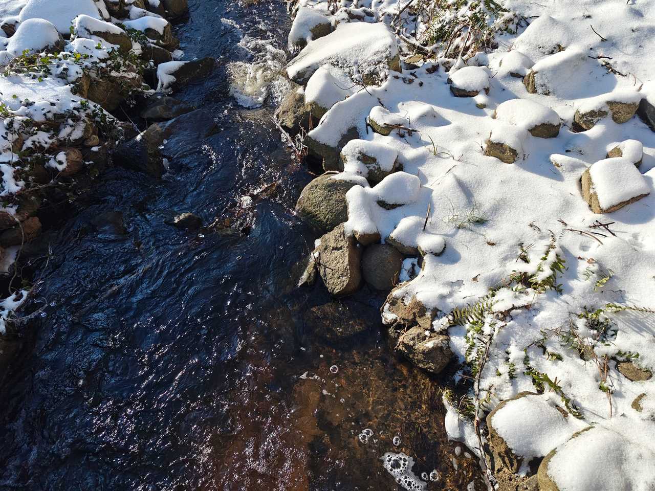 A photo of a stream and snowy rocks taken with the OnePlus 12’s main camera.