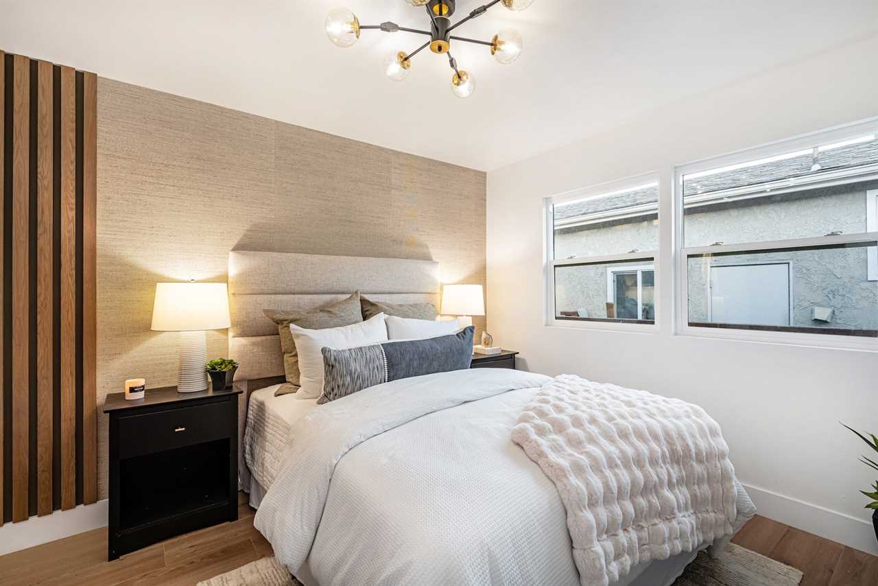 A bedroom with a textured wall and a large bed.