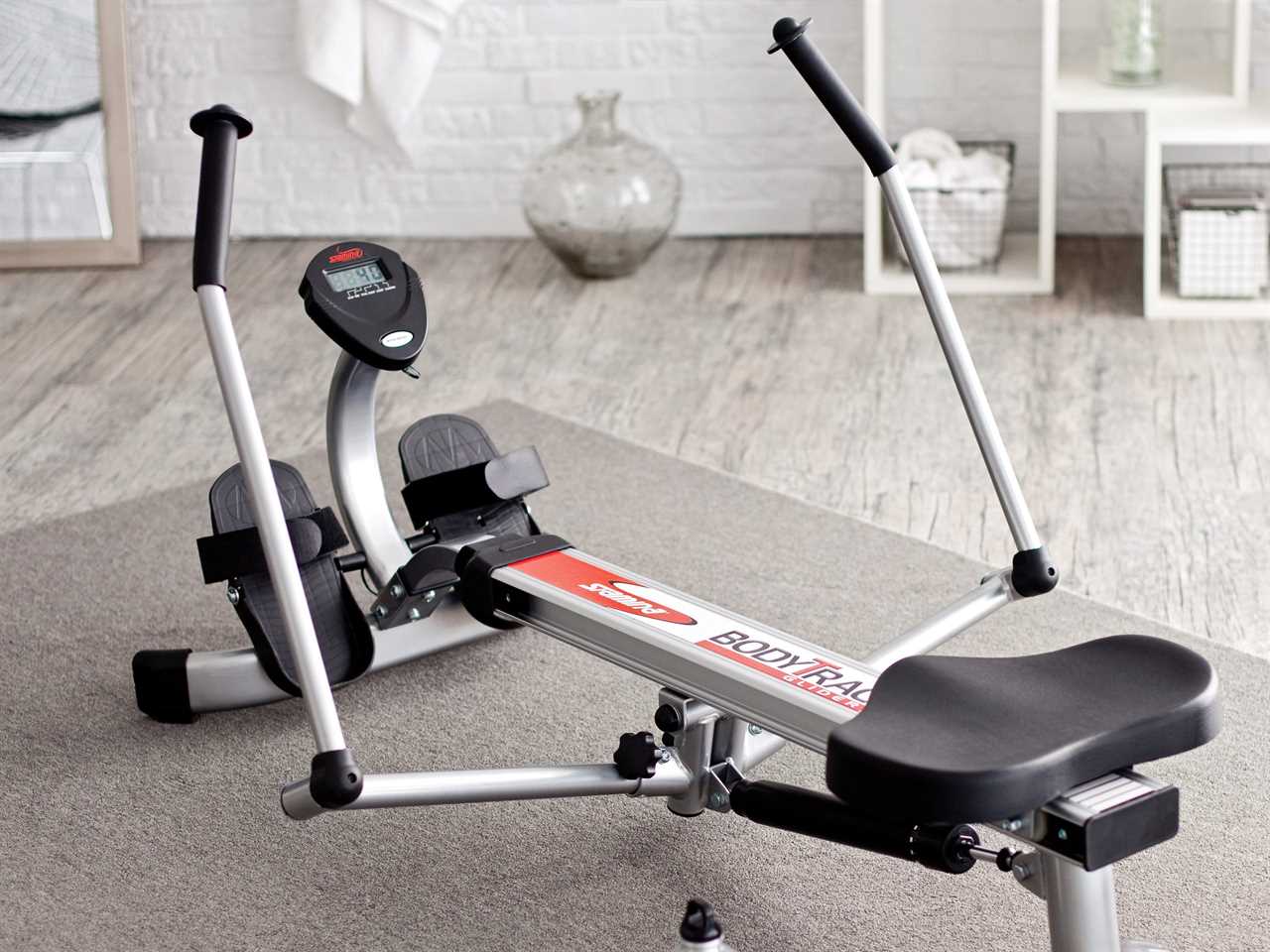 a Stamina BodyTrac Glider 1050 Rowing Machine sits in a gray and white room.