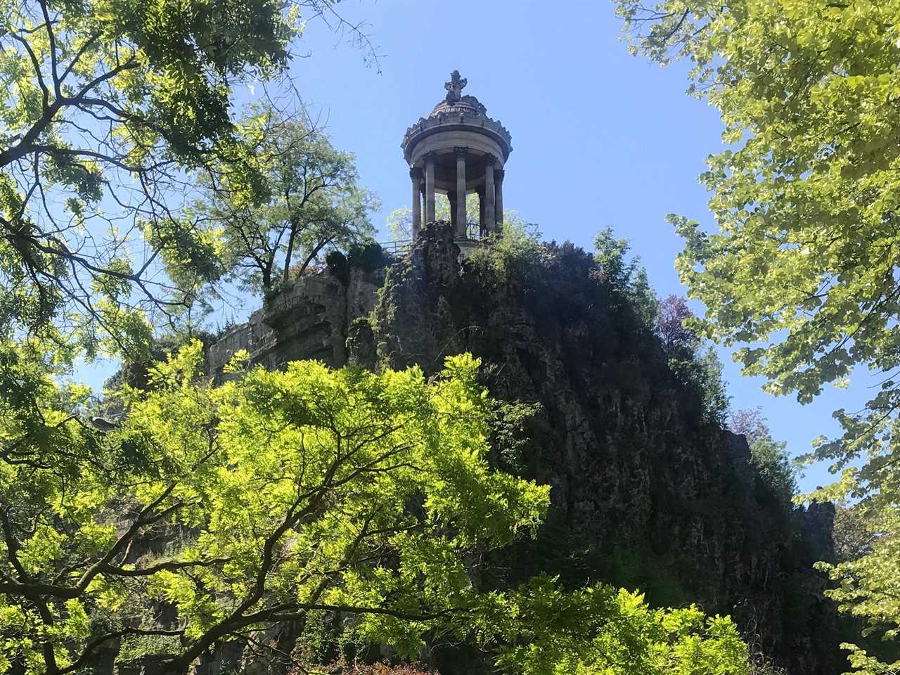 shot of a stone pergola on a hill in buttes chaumont park in paris