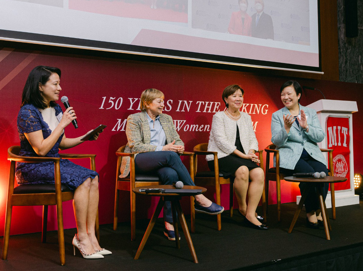 Four women seated  on stage in a panel discussion 