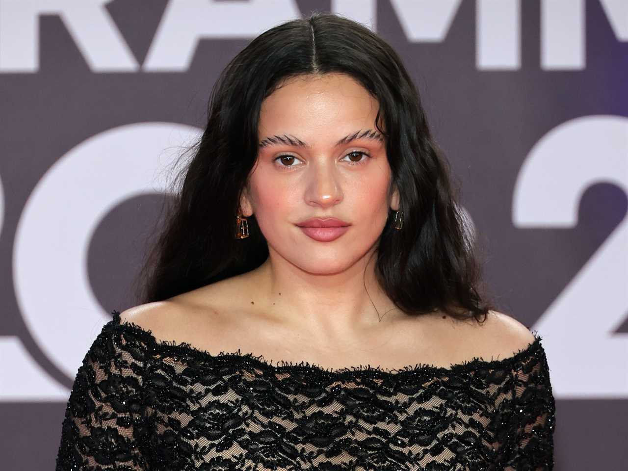 Rosalia poses in a black off-the-shoulder dress at the 2023 Latin Grammy Awards.