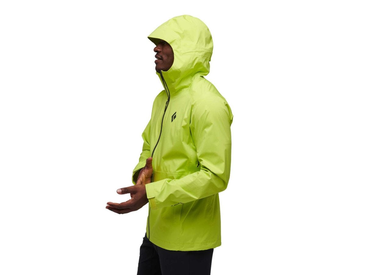 A man wearing a bright green rain jacket from Black Diamond